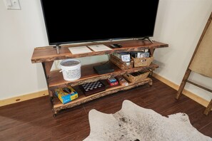Eine Holz-Multifunktionszeile mit Fernseher, Büchern und Aufbewahrungskörben.