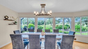 Un comedor con una mesa grande, seis sillas y un candelabro.