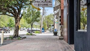 A brick sidewalk with a 'PACKAGE STORE' sign, a tree, and parked cars. - Charming year-round beach home in Indian Town, Old Saybrook (Old Saybrook)