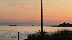 A flagpole on a beach with a bench nearby. - Charming year-round beach home in Indian Town, Old Saybrook (Old Saybrook)