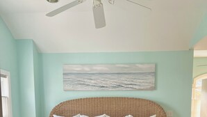 A bed with a woven headboard, white bedding, and a beach-themed pillow. - Charming year-round beach home in Indian Town, Old Saybrook (Old Saybrook)