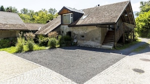 Ein rustikales Gebäude mit einem geneigten Dach, einem kleinen Fenster und einer Treppe, die zu einer Holterrasse führt.