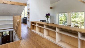 Ein modernes Interieur mit Holzboden, weißen Wänden und einer eingebauten Holzregaleinheit.