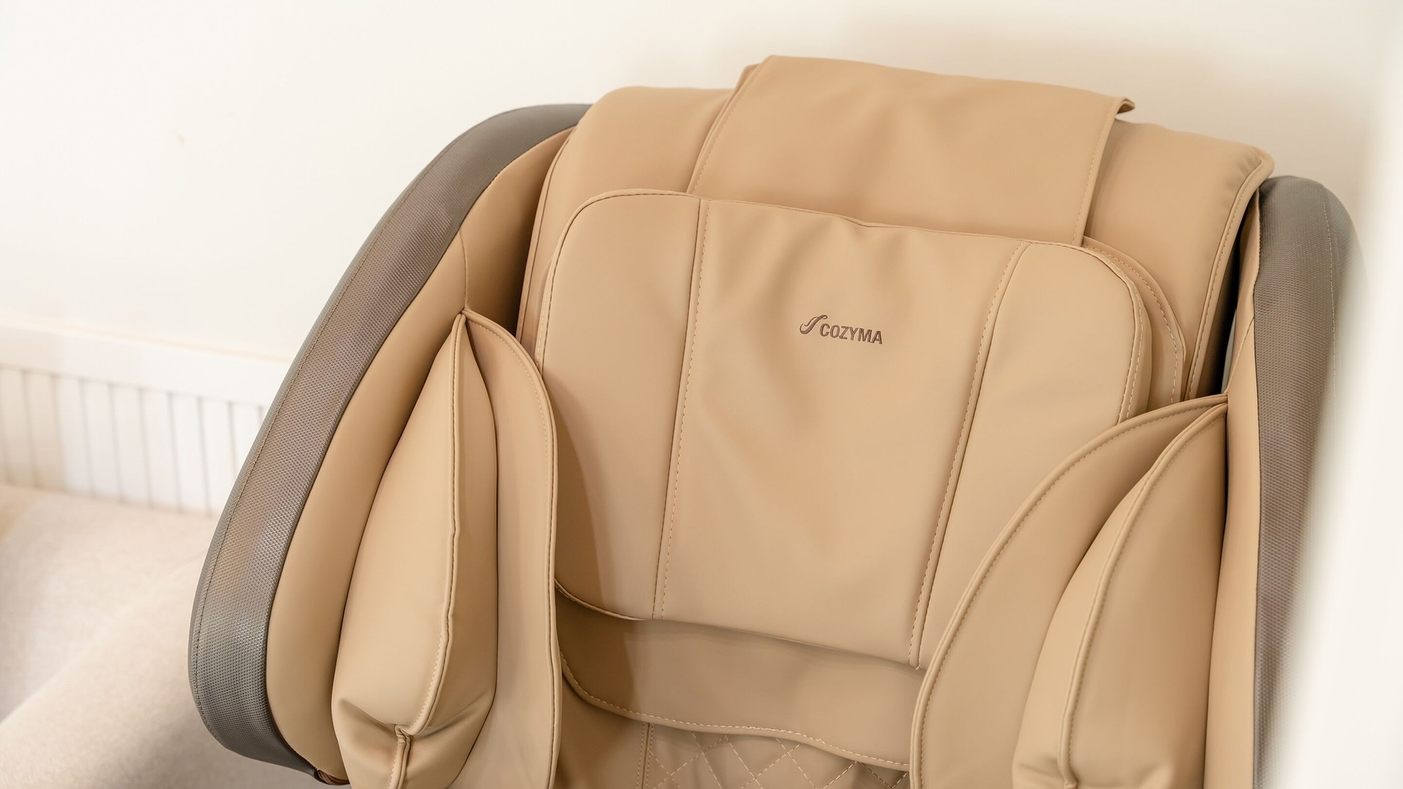 Una silla de masaje color bronce con el nombre de marca 'COSZYMA' visible en el respaldo.