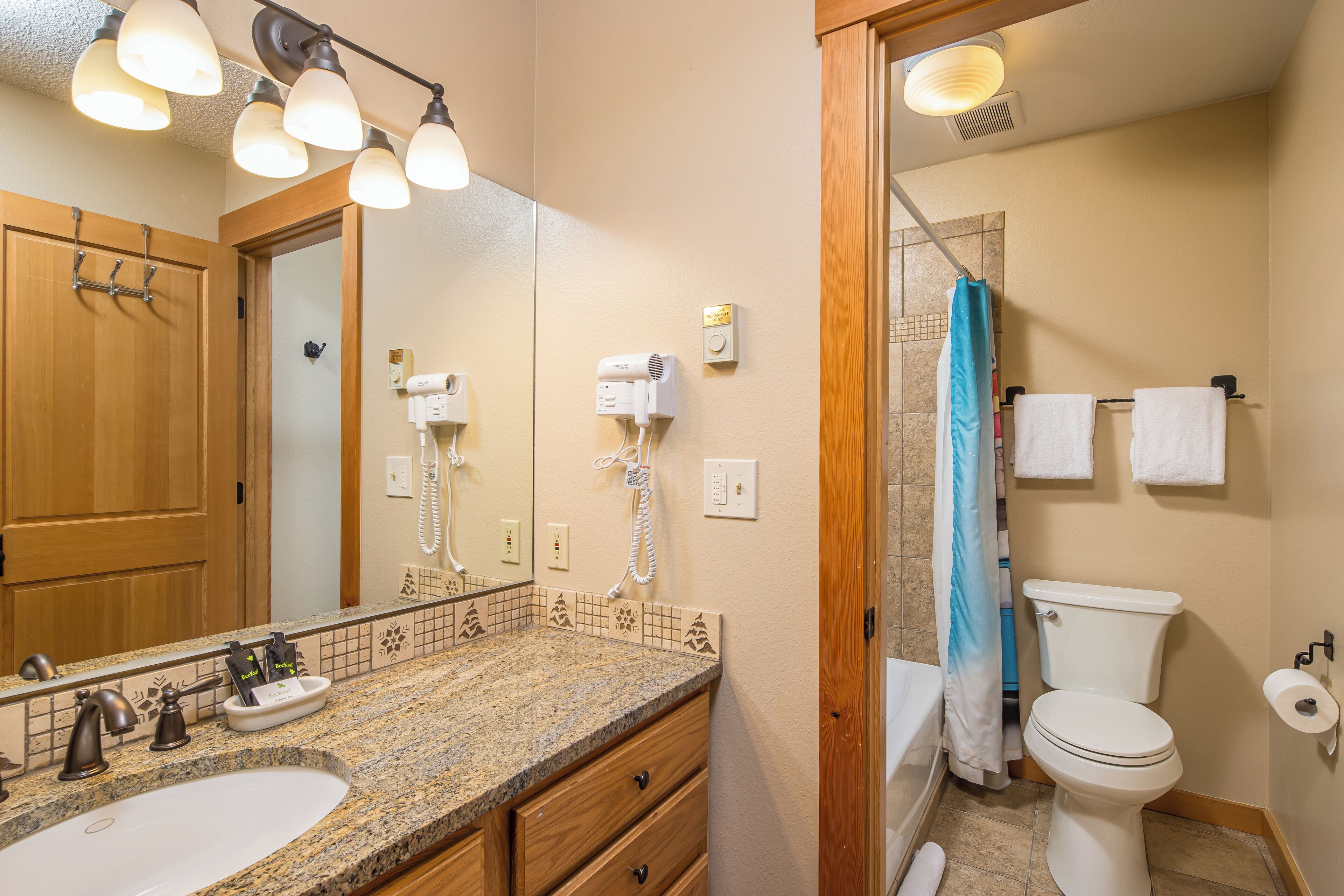 A bathroom with a sink, mirror, towel rack, and toilet.