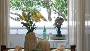 Mesa posta com pratos, guardanapos e um vaso de flores.