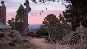 A hammock, a brick chimney, and a path leading to a scenic view. - Marin Castle: Private Resort w Top of World Views, Hot Tub & Mini Golf, 30 Acres (Lagunitas)
