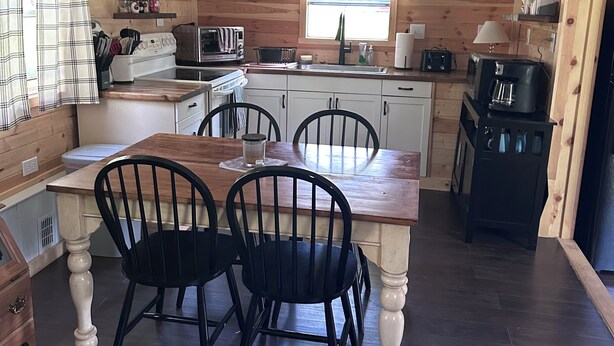 A compact kitchen with a dining table, chairs, and a coffee machine. - Private & Cozy! Close to the Clarion River & State Parks!- Camp Harv est.1994 (Clarington)