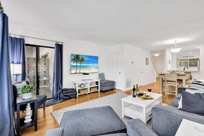 A modern living room with grey sofas, a white coffee table, and a dining area with a wooden table and chairs. - 77 Springwood Villa @ Forest Beach | Pool View | Minutes to Coligny | 10 min walk to the Beach (Hilton Head Island)