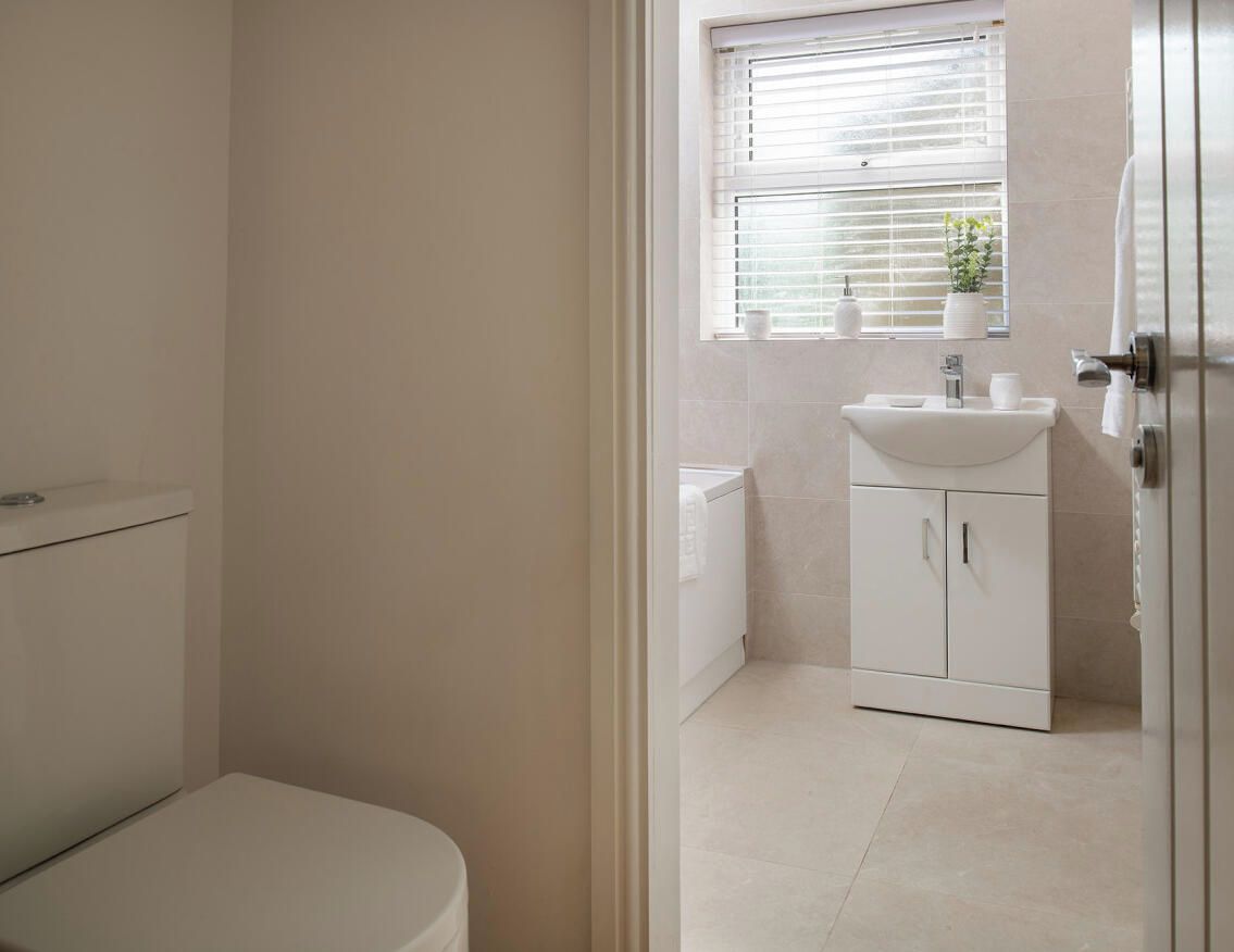 Ein Badezimmer mit Toilette, Waschbecken und einem Schrank.