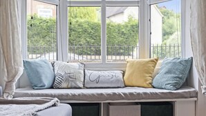 A window seat with cushions and a view of greenery outside.