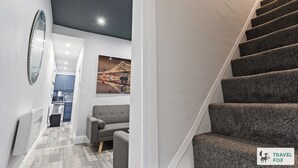Een moderne hotelkamer met een trap, een eetgedeelte en een woongedeelte.