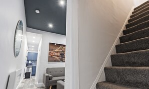 A modern hotel room with a staircase, a dining area, and a living space. - Bella`s House: Motor Point Arena (Nottingham)