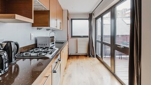 Une cuisine moderne avec des meubles en bois, une cuisinière à gaz et une machine à café.