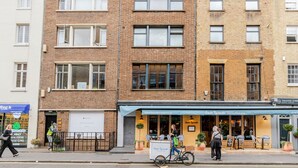 Une rangée d’immeubles à plusieurs étages, avec un restaurant appelé « Santa Remedio » situé au milieu.