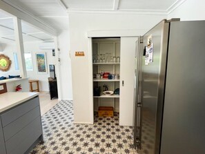 A kitchen with a tiled floor, a stainless steel refrigerator, and a white cabinet with a 'KEYS' sign.