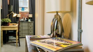 A room with a desk, lamp, and magazines. - Betts Private room at Bicester Heritage (Bicester)