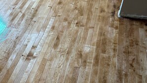 A wooden floor with visible wear and tear.