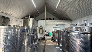 Un'ampia struttura industriale con serbatoi in acciaio inossidabile e un soffitto alto.