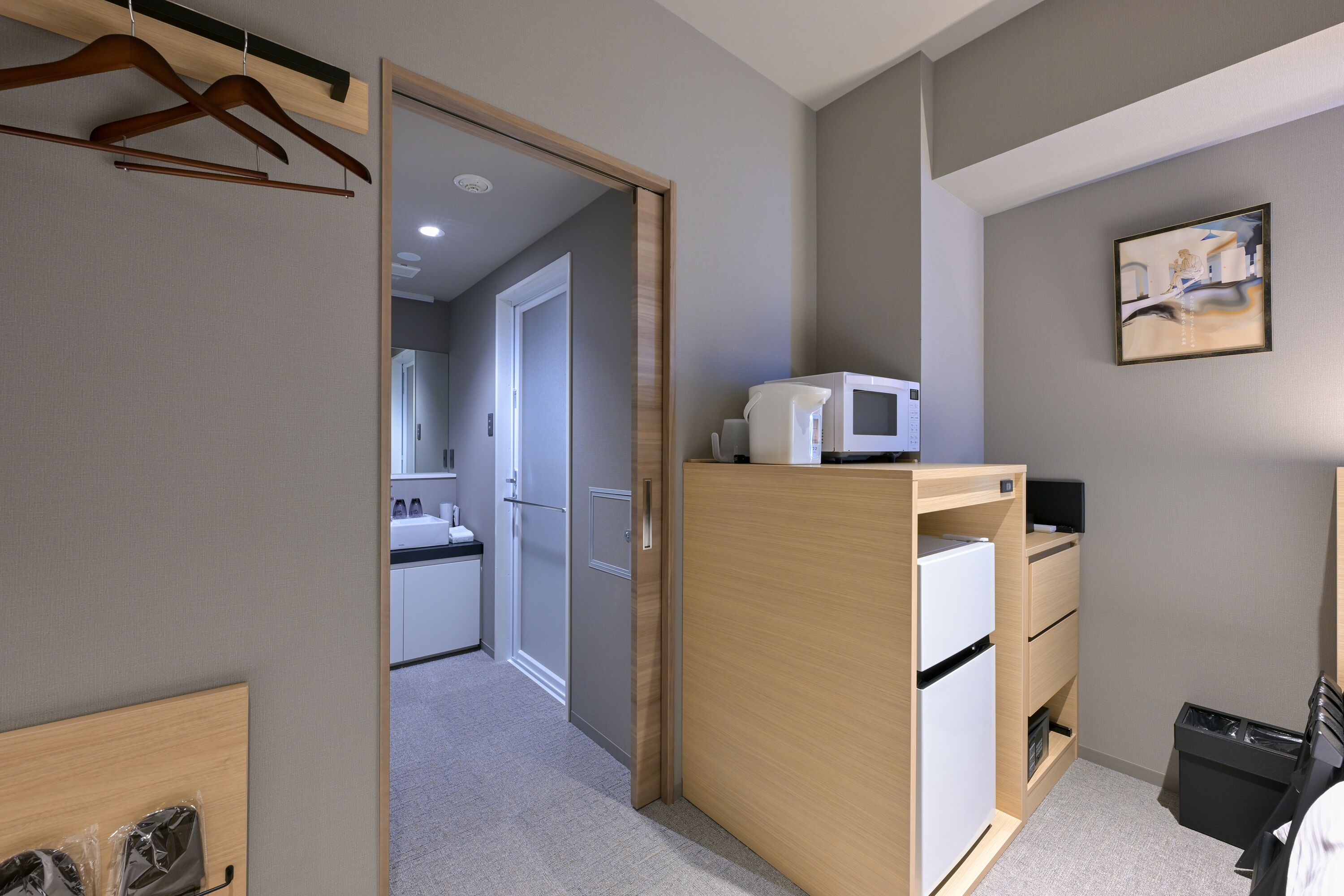A modern bedroom with a wooden wardrobe, a bed, and a small desk.