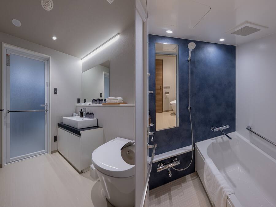 A modern bathroom with a toilet, sink, and bathtub.