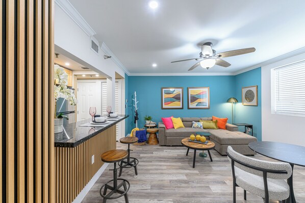 Un salon moderne avec un canapé, une table basse et un coin bar.
