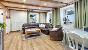 A cozy living room with a brown leather sofa, a wooden coffee table, and a white chair.