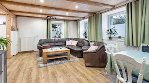 A cozy living room with a brown leather sofa, a wooden coffee table, and a white chair.