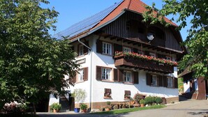 Un chalet traditionnel doté d’un toit en pente, de balcons en bois et de jardinières.