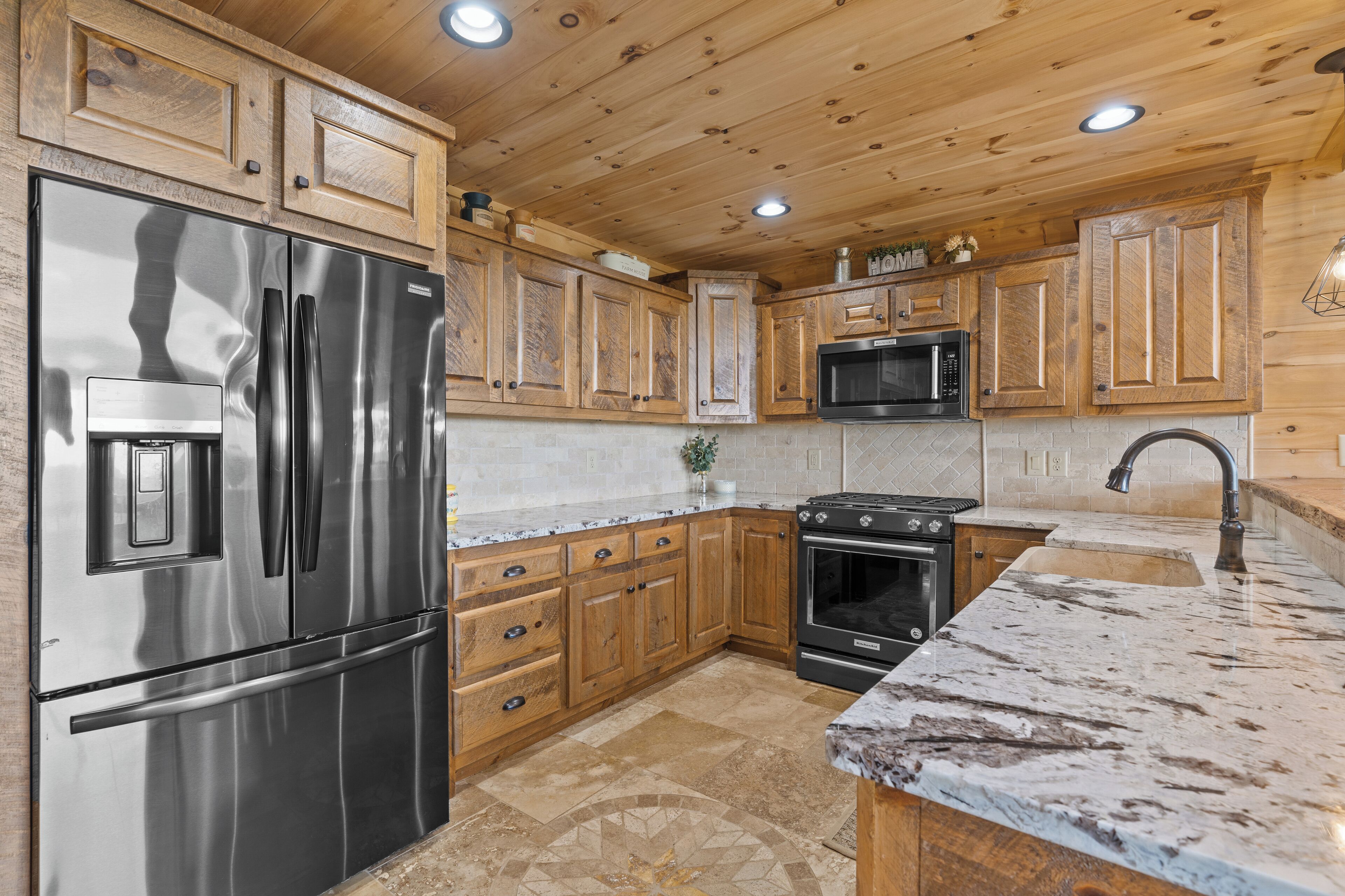 A kitchen with wooden cabinets, stainless steel appliances, and a granite countertop.