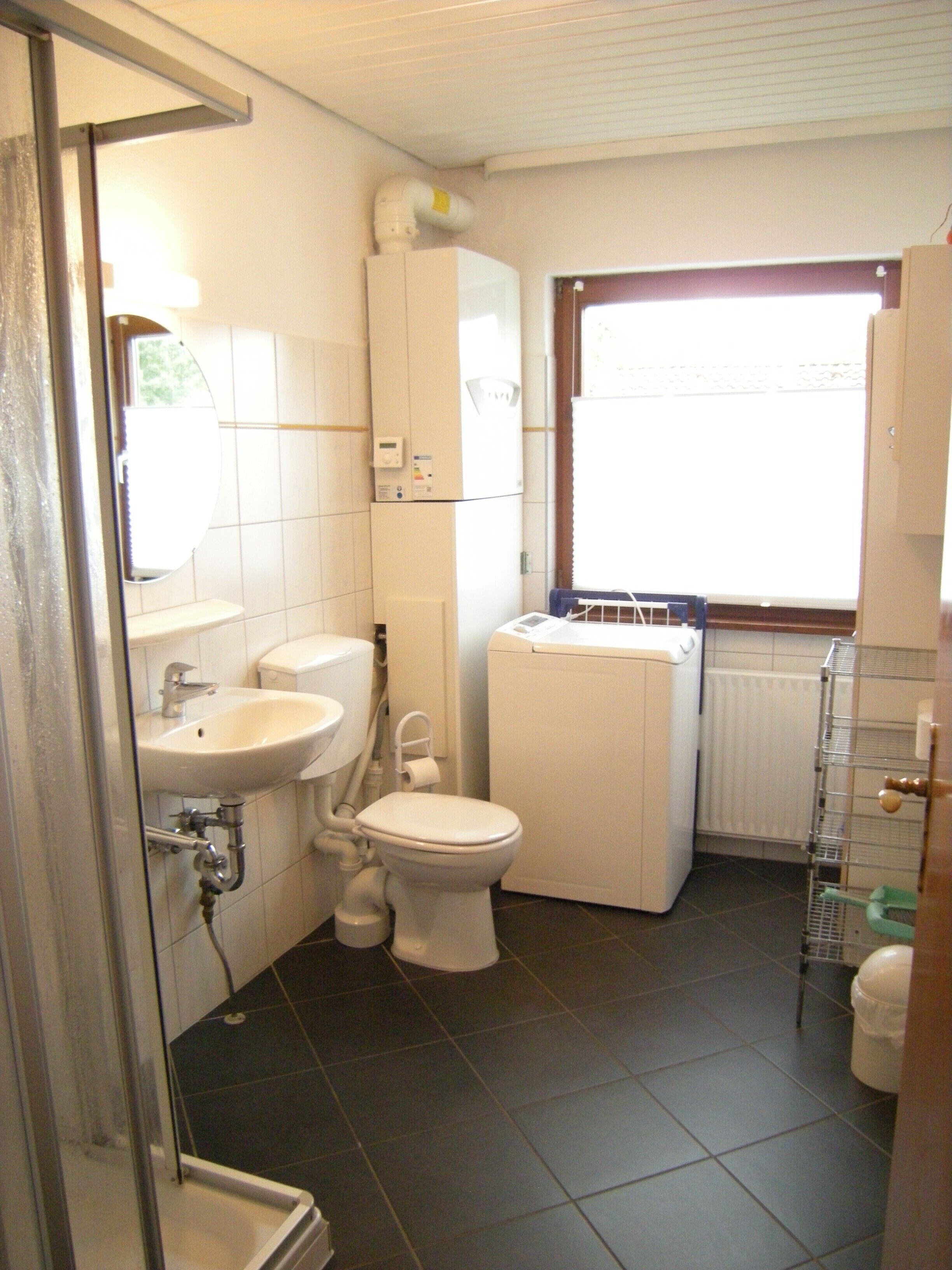 Een badkamer met toilet, wastafel en douche.