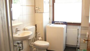 Een badkamer met toilet, wastafel en douche.