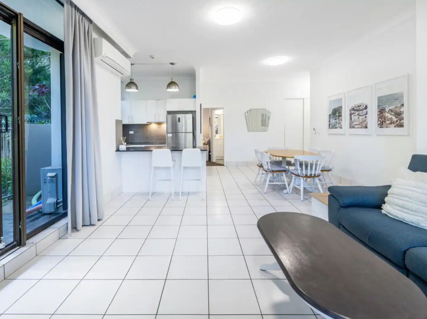 A modern apartment with a kitchen, dining area, and living room.