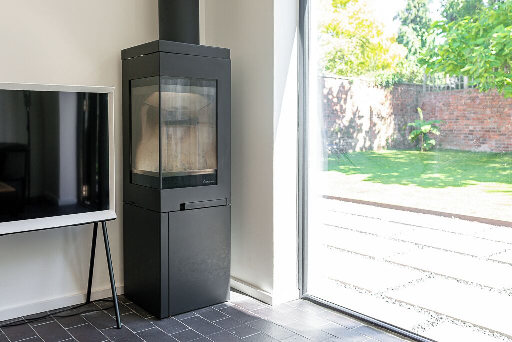 A modern kitchen with a built-in stove, a large window, and a view of a garden.
