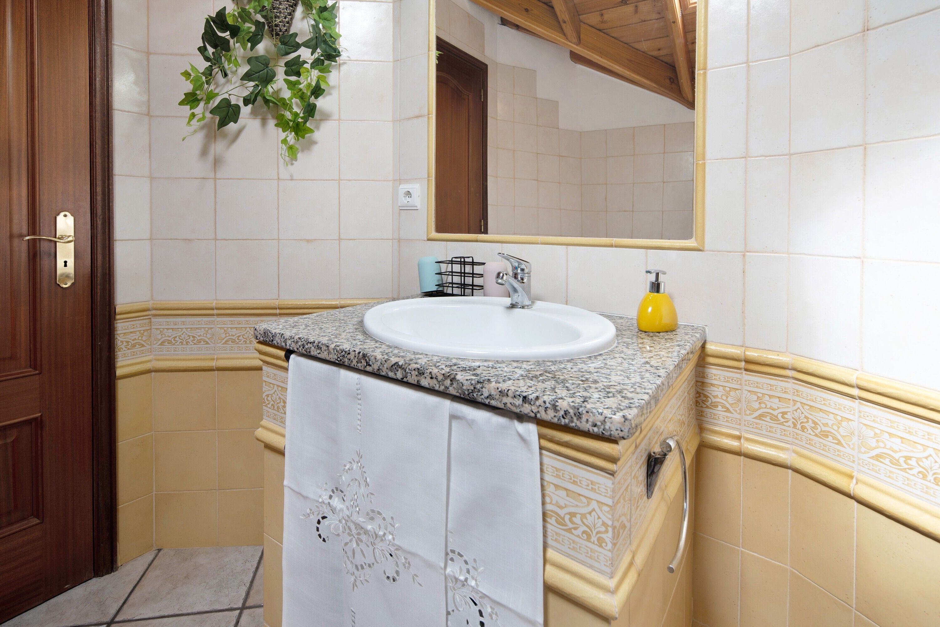 Ein Badezimmer mit Waschbecken, Spiegel und Handtuchhalter.