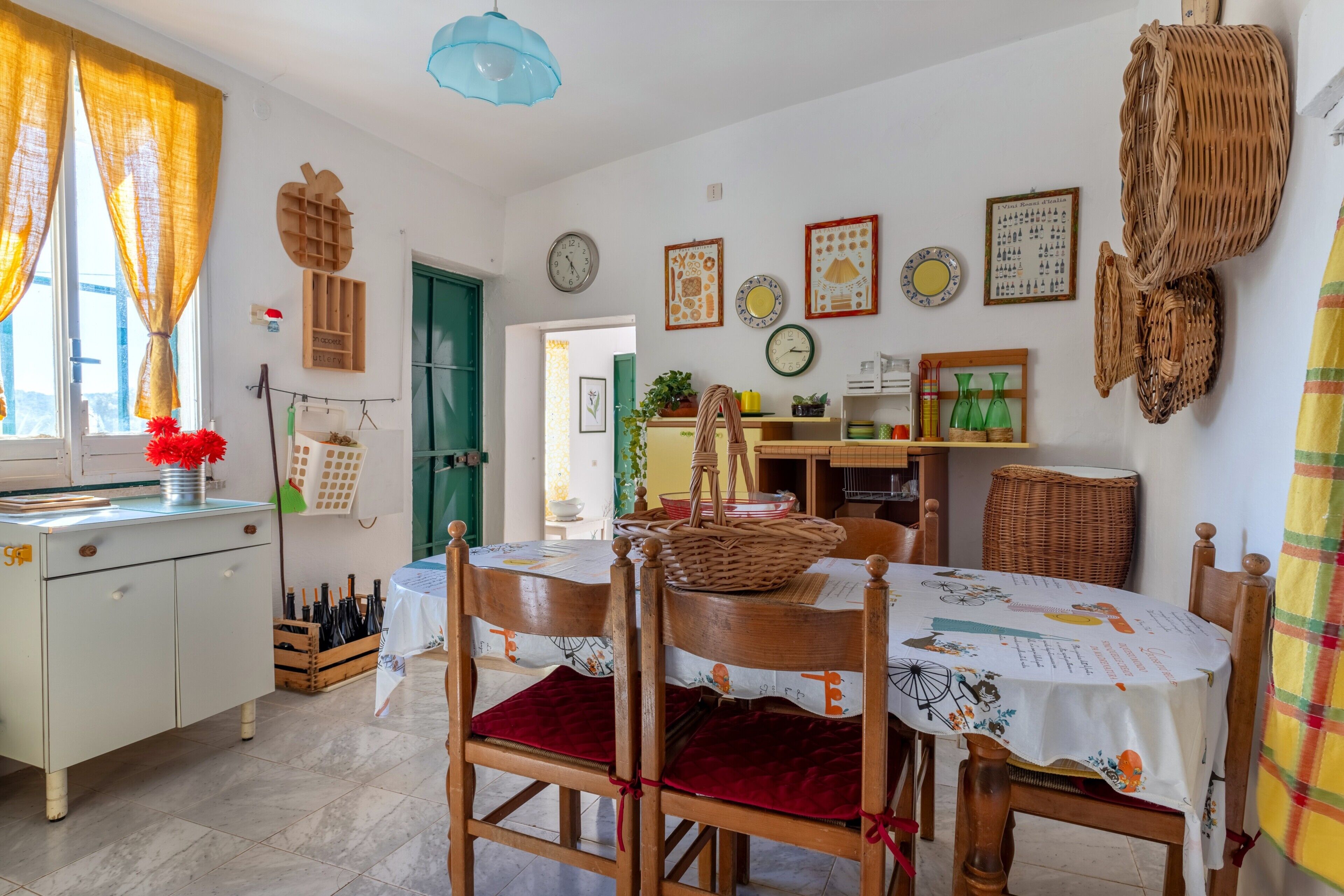 Un'area pranzo con tavolo, sedie e una cucina sullo sfondo.