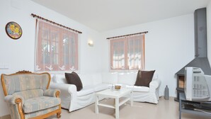 A living room with a sofa, armchair, and a small table. - Holiday Home 'Chalet Independiente Costa Daurada' with Private Garden, Balcony and Air Conditioning (Roda de Berà)