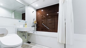 Un baño moderno con lavamanos, espejo y retrete blancos.