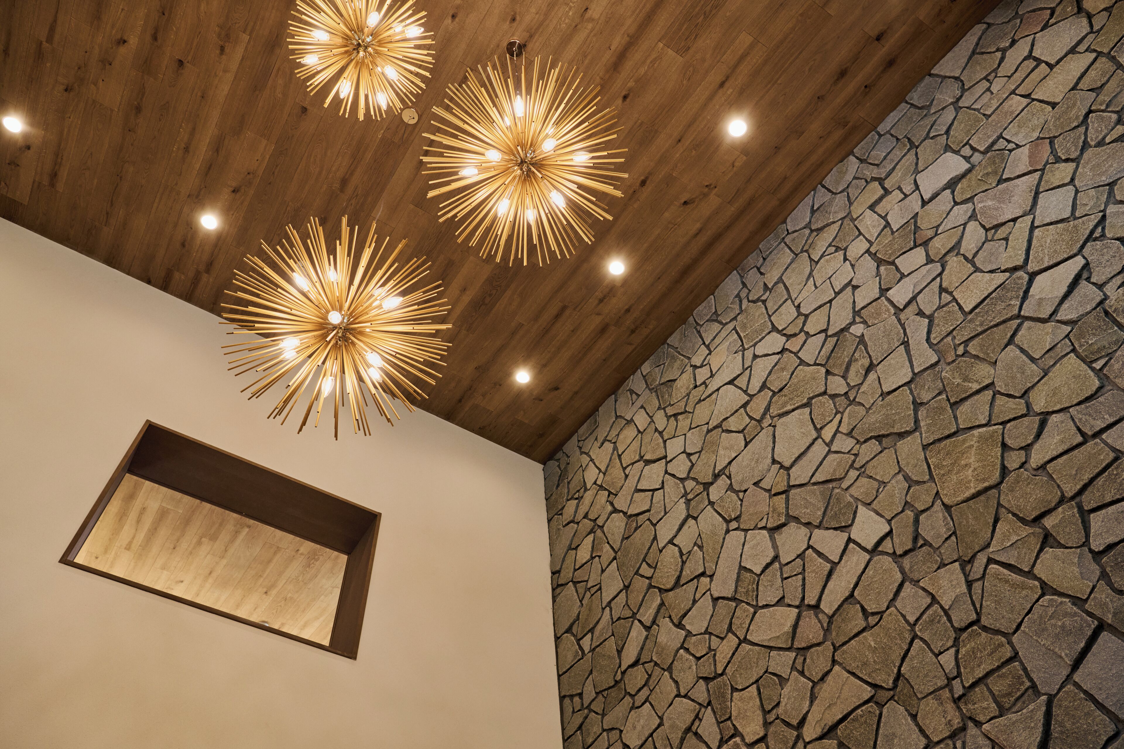 A ceiling with wooden beams and stone wall.