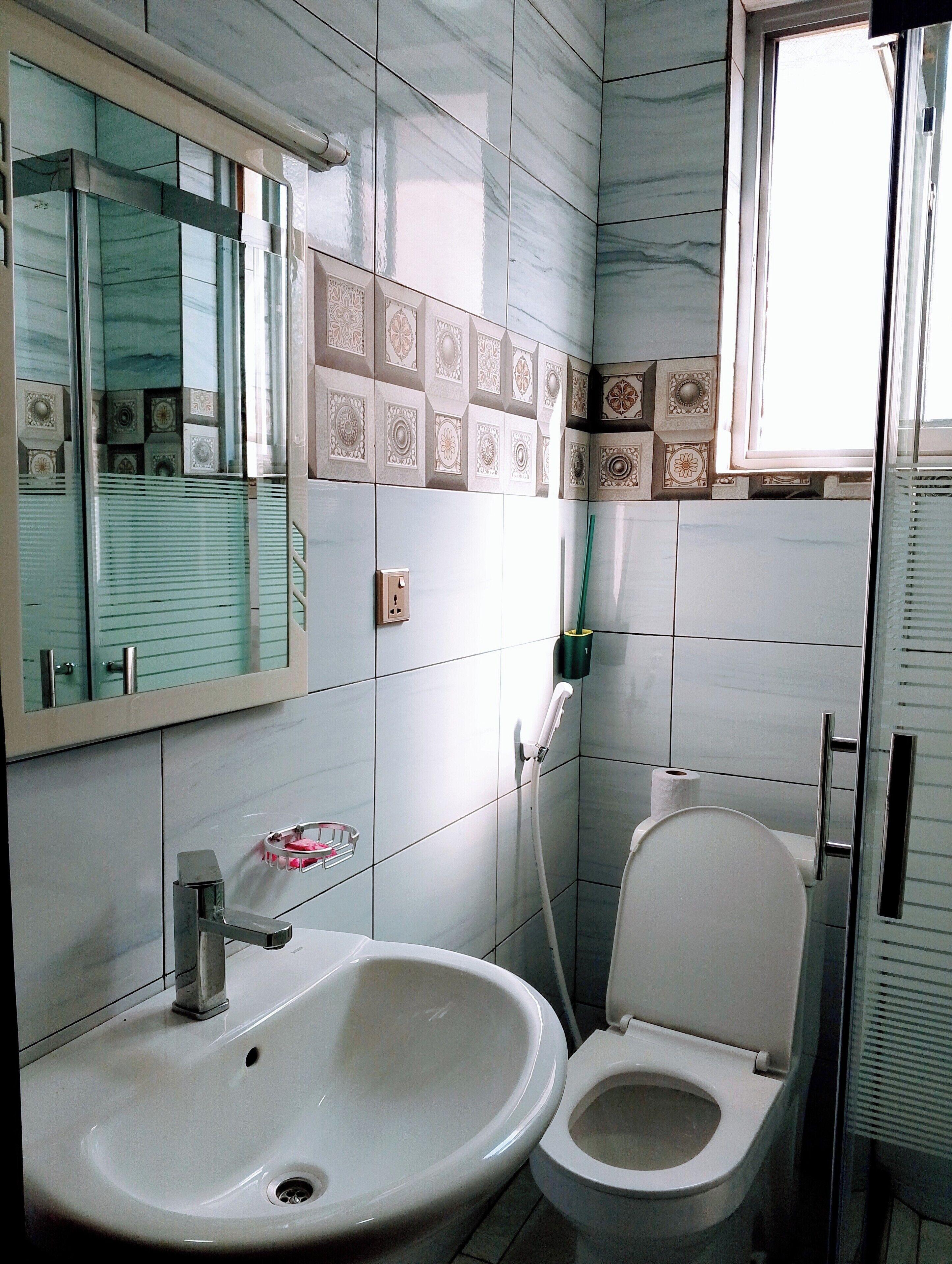 A bathroom with a sink, toilet, and a mirror.