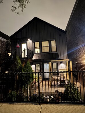 A two-story building with a balcony and a small porch area. - Charming 2-bedroom 1 bathroom Bridgeport Chicago (Chicago)