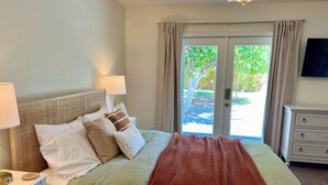 A bedroom with a bed, nightstands, a dresser, and a view of the outdoors. - Private retreat with gym, hot tub, pool & playroom (Phoenix)