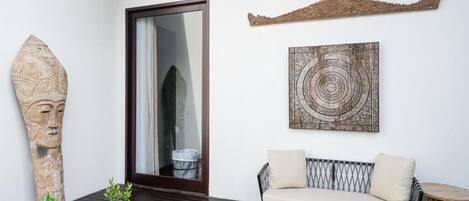 A modern interior with a sofa, a decorative wall piece, and a stone sculpture.