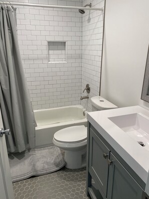 Une salle de bain avec une baignoire blanche, des toilettes et un lavabo.