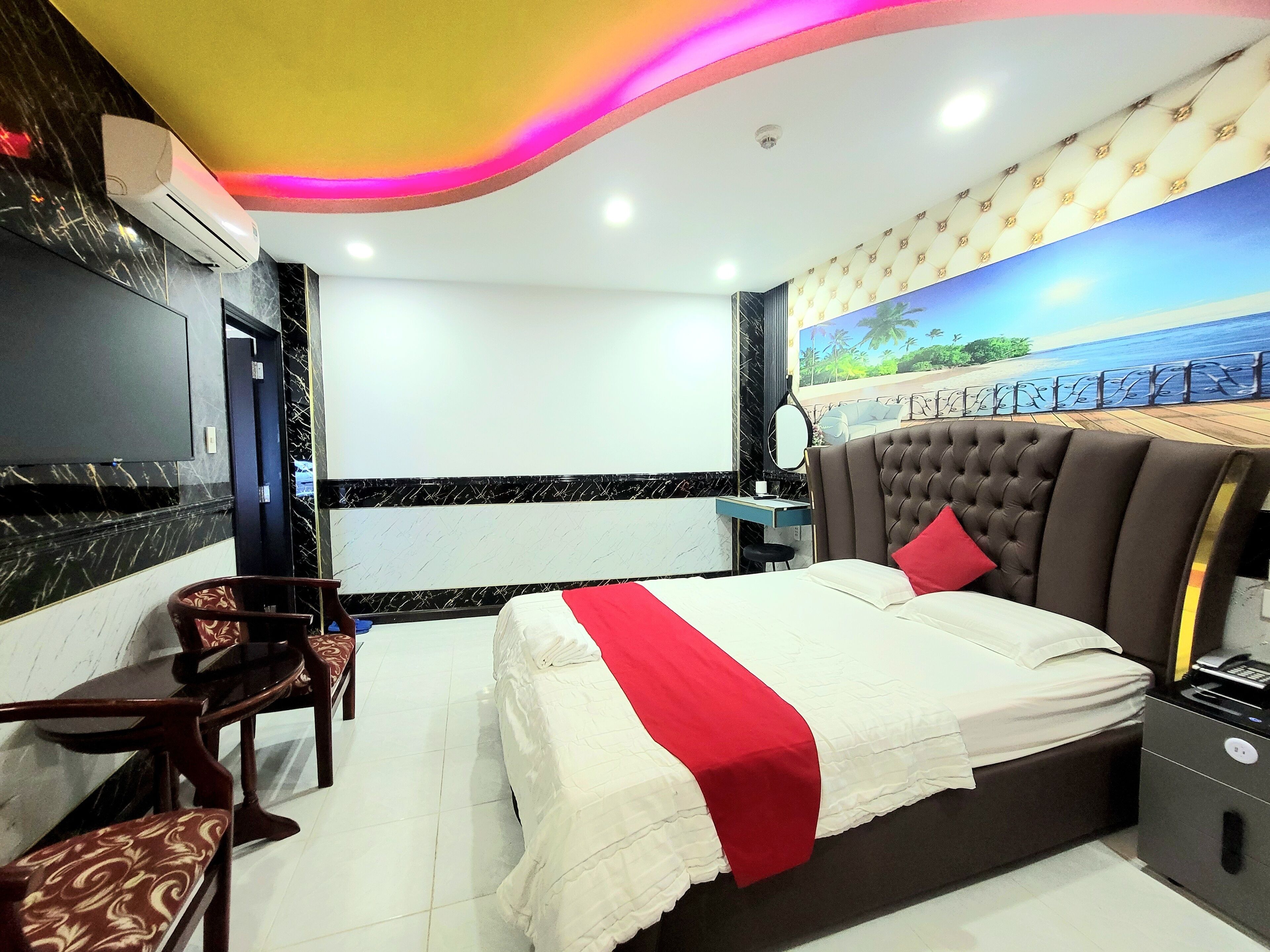 A hotel room with a bed, a desk, a chair, and a TV.