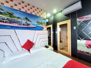 A hotel room with a large bed, a red pillow, a painting of a tropical scene, an air conditioning unit, and a wooden door. - T&T Hotel (Ho Chi Minh City)