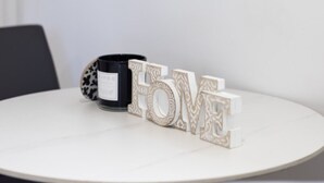 Una mesa redonda con una taza negra y letras decorativas que deletrean 'LOVE'.