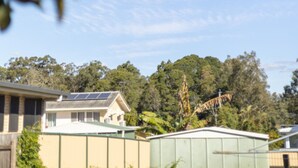 Un barrio residencial con casas, un edificio verde y un puente al fondo.