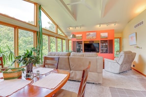 Relax in this stylish living area with a sofa, recliner, and dining table, perfect for unwinding and enjoying the view.