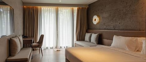 Quarto de hotel moderno com uma cama grande, uma escrivaninha e uma cadeira.
